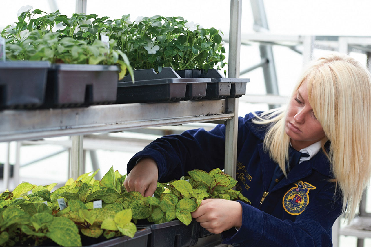 FFA student tending to greenhouse